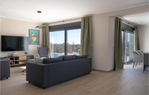 ein Wohnzimmer mit einem Sofa und einem TV in der Unterkunft Cozy Home In Krnica With Kitchen in Krnica