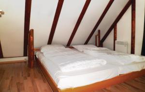 Cette chambre comprend un lit avec un cadre en bois. dans l'établissement Ferienhaus 22 In Frankenau, à Frankenau
