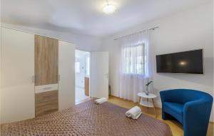 ein Schlafzimmer mit einem Bett und einem blauen Stuhl in der Unterkunft Cozy Home In Valbandon With Kitchen in Valbandon