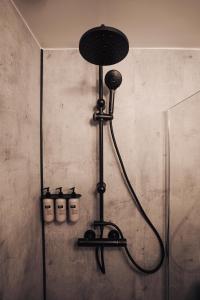 a shower in a bathroom with four bottles on the wall at Brim Hotel in Reykjavík