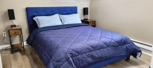 a purple bed in a bedroom with two night stands at Blue Wave 2 bedroom suite in Saskatoon