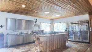 a kitchen with a wooden ceiling and a counter with chairs at Hidden Bear Retreat Center in Clark Fork