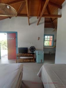 a bedroom with a bed and a desk in a room at Chalés Vila das Cachoeiras in Diamantina