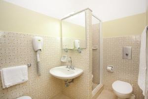 a bathroom with a sink and a toilet and a mirror at Hotel President in Alba Adriatica +22 photos