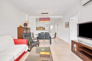 uma sala de estar com um sofá e uma televisão em Luxury Apt, Beach, Pool open 365 days, Near Javea & Denia em El Verger