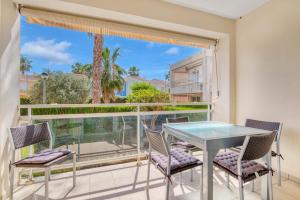 patio con mesa de cristal y sillas en el balcón en Luxury Apt, Beach, Pool open 365 days, Near Javea & Denia, en El Verger