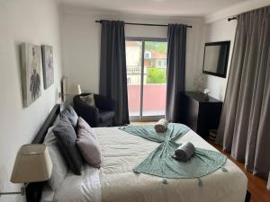 a bedroom with a bed with towels on it at Natural Living Vacations in Furnas