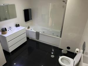 een badkamer met een toilet, een wastafel en een bad bij Natural Living Vacations in Furnas