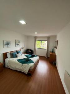a bedroom with a large bed and a wooden floor at Natural Living Vacations in Furnas