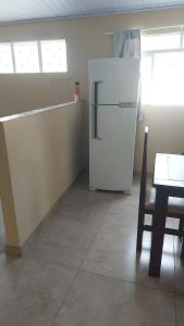 a white refrigerator in a room with a table at Acordar com o cantar do passaro in Jabuticabal