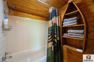 een badkamer met een douchegordijn en een bad bij 3BR Cabin On the White River with Boat Launch - Great Fishing - CCWC in Mountain View