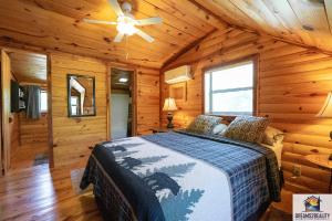 een slaapkamer met een bed in een blokhut bij 3BR Cabin On the White River with Boat Launch - Great Fishing - CCWC in Mountain View