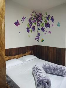 um quarto com uma cama com flores na parede em Hostal Casa Madrigal em Filandia