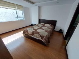 1 dormitorio con 1 cama en una habitación con ventana en Departamento nuevo, elegante y muy cómodo., en Loja
