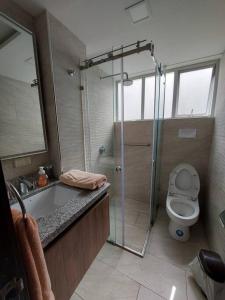 a bathroom with a shower and a toilet and a sink at Departamento nuevo, elegante y muy cómodo. in Loja