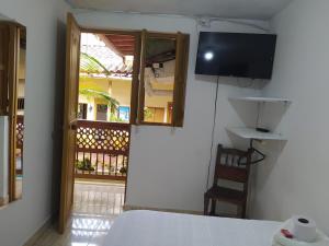 a bedroom with a bed and a television on the wall at Hotel Colonial in Jardin