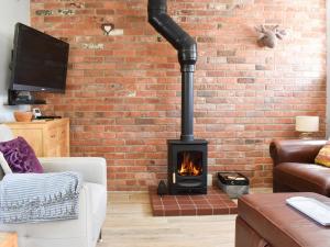 a fireplace in a living room with a brick wall at White Heather Barn in Swanwick