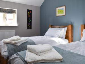 a bedroom with two beds with towels on them at White Heather Barn in Swanwick