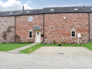 a brick building with a white door and a yard at White Heather Barn in Swanwick