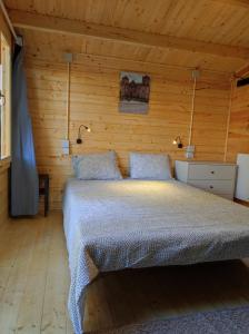 1 dormitorio con 1 cama en una habitación de madera en Parque de Campismo de Fão en Fão