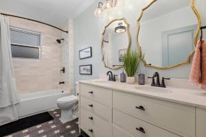 a bathroom with a sink and a toilet and a mirror at NEW! High-end Manchester Home w/ a hot tub in Pittsburgh