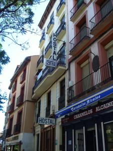 un edificio con letreros en el costado en Hostal Central Zaragoza, en Zaragoza