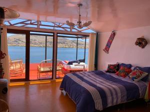 a bedroom with a bed and a view of the water at Uros TITIKAKA the Best lodge in Puno