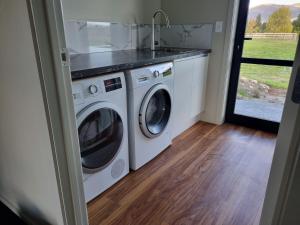 a laundry room with a washer and dryer at Ben Ohau Views On The Drive in Twizel