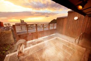 d'un bain à remous sur un balcon avec vue sur l'océan. dans l'établissement Atarayo Nishiizu Onsen, à Izu