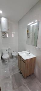 La salle de bains est pourvue d'un lavabo, de toilettes et d'un miroir. dans l'établissement Seaview Apartment 100m from beach, à Luz