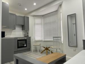 a kitchen with a table and chairs in a kitchen at EAST LONDON APARTMENTS SELF check in in London