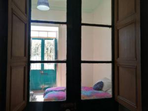 vistas a través de una ventana de un dormitorio con 2 camas en Departamento Independiente en Casa Patrimonial en Vicuña