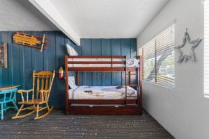 a bedroom with a bunk bed and a chair at 04- Kodiak Bear At Village Suites Inn in Big Bear Lake