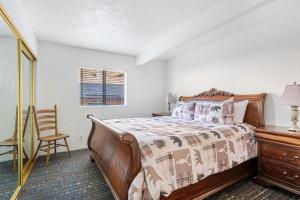 a bedroom with a bed and a chair and a dresser at 04- Kodiak Bear At Village Suites Inn in Big Bear Lake