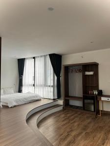 um quarto com uma cama e uma grande janela em Memory Inn Dalat em Da Lat