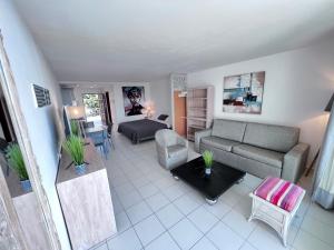 uma sala de estar com um sofá e uma cama em Studio Tortola Orient Bay VUE MER em São Martinho