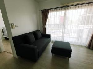 a living room with a black couch and a ottoman at Luxury 2 bedrooms condo in Kho Takiab in Hua Hin