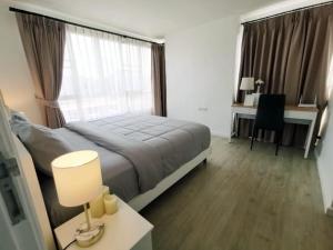 a bedroom with a large bed and a desk with a lamp at Luxury 2 bedrooms condo in Kho Takiab in Hua Hin