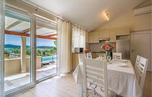 a dining room with a table and a kitchen with a view at Awesome Home In Pomer With House Sea View in Pomer