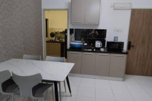 a kitchen with a white table and chairs in a room at HMM Lili - Nilai in Nilai
