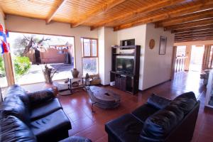 - un salon avec un canapé en cuir et une télévision dans l'établissement Inti & Killa Hostal, à San Pedro de Atacama
