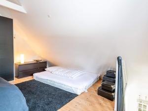 a bedroom with a white bed and a night stand at Holiday home Vejers Strand XIX in Vejers Strand