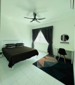 a bedroom with a bed and a ceiling fan at Iseymia Homestay in Kampong Alor Gajah