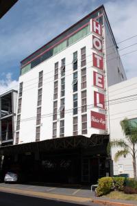 un edificio blanco con un cartel de hotel rojo en él en Palacio Rojo Hotel Familiar, en Morelia