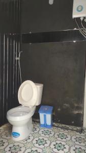 a bathroom with a toilet and a black wall at Amikaje Farm in Xuan An