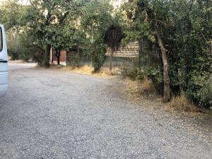 een weg met bomen en een hek aan de zijkant bij Habitación con baño privado in Santiago