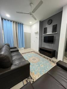 a living room with a couch and a flat screen tv at DRest Homestay Desa Aman 