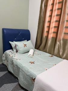 a bedroom with a bed with a blue headboard at DRest Homestay Desa Aman 