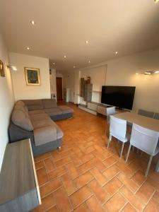 un salon avec un canapé, une table et une télévision dans l'établissement Casa Giulietta, à Nettuno