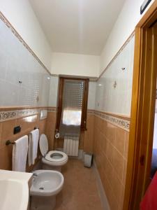 a bathroom with a toilet and a sink at Casa Giulietta in Nettuno +14 photos